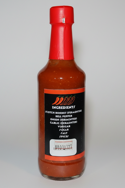 A bottle of Magical Farms Scotch Reign hot sauce with a red cap and black label, filled with reddish-brown sauce, isolated on a white background.
